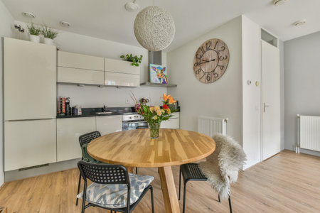 a kitchen and dining area in a house with wood floors, white cabinets and an open door leading to...