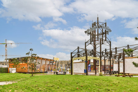 Amsterdam, Netherlands - 10 April, 2021: a clock tower in the middle of a grassy area with trees and buildings in the background on a sunny dayのeditorial素材