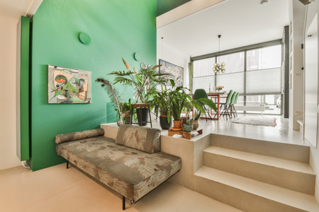 a living room with plants on the wall and stairs leading up to the second floor in front of the houseのeditorial素材