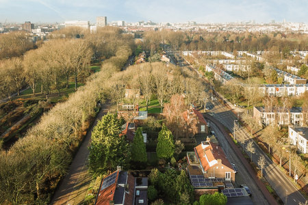 Amsterdam, Netherlands - 10 April, 2021: a city from the top of a building on a hill with trees and buildings in the fore - swaysのeditorial素材