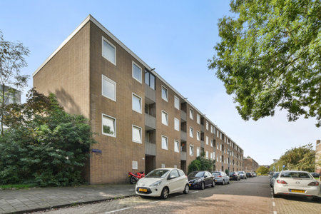 Amsterdam, Netherlands - 10 April, 2021: a street scene with cars parked on the side of the road in front of buildings and people walking down the streetのeditorial素材