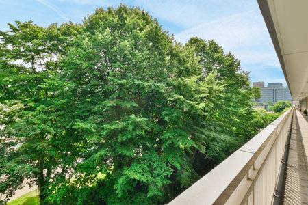 a balcony with trees and buildings in the background, taken from an apartments second floor window looking out onto the streetのeditorial素材