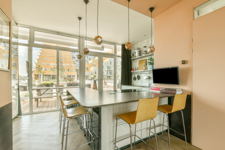 Amsterdam, Netherlands - 10 April, 2021: a kitchen and dining area in a house with large sliding glass doors that open onto the patio to an outdoor terraceのeditorial素材