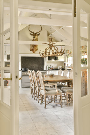 Amsterdam, Netherlands - 10 April, 2021: a kitchen and dining area in a house with deer heads on the wall above the door to the living roomのeditorial素材