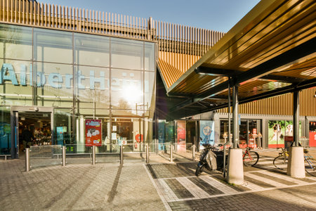 a person on a bike in front of a building that is reflecting the sky and buildings behind them, as if theyreのeditorial素材