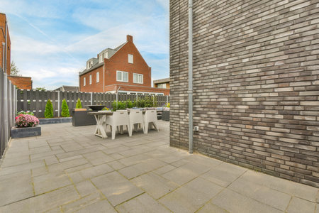 Amsterdam, Netherlands - 10 April, 2021: an outside area with tables and chairs in the middle of the photo, there is a house on the other sideのeditorial素材