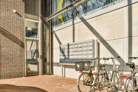 two bikes parked next to each other bikes in front of a building with the sun shining through the...