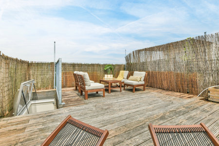 a wooden deck with two chairs and a fire pit in the middle one chair is on top of the other