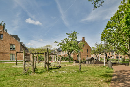 Amsterdam, Netherlands - 10 April, 2021: a park in the middle of an urban area with houses and trees on either side of it, there is a path that leadsのeditorial素材