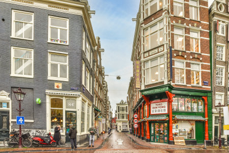 a city street with buildings and people walking on the sidewalk in front of shops, stores and restaurants under blue skyのeditorial素材