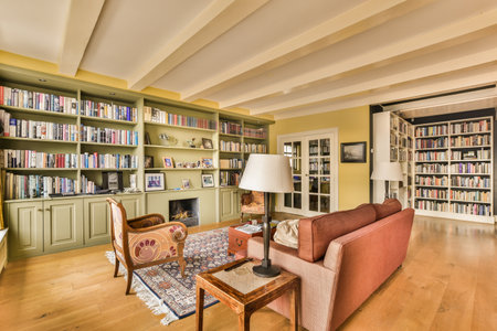 Amsterdam, Netherlands - 10 April, 2021: a living room with lots of books on the shelves and a couch in the center of the room is emptyのeditorial素材