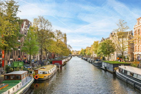 some boats in the water and buildings on both sides with blue skies above them, as seen from across the canalのeditorial素材