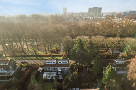 Amsterdam, Netherlands - 10 April, 2021: an aerial view of houses and trees in the distance, taken from a birds - eye view on a sunny dayのeditorial素材