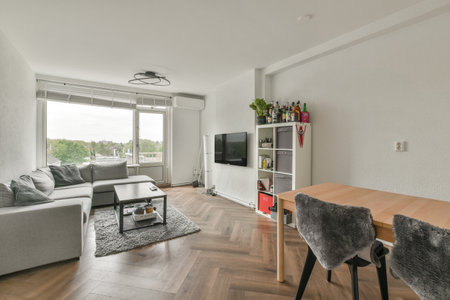 Amsterdam, Netherlands - 10 April, 2021: a living room with wood flooring and white walls, including a large window looking out onto the city skylineのeditorial素材