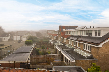 Amsterdam, Netherlands - 10 April, 2021: a city with buildings and trees in the foregrounds, taken from an overcasted window on a cloudy dayのeditorial素材