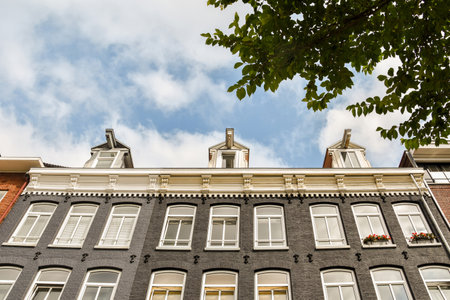 an old building with windows and sky in the background, as seen from below on a bright sunny...