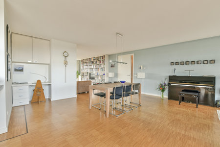 Amsterdam, Netherlands - 10 April, 2021: a living room with a piano in the middle and an open kitchen on the other side, including a dining tableのeditorial素材