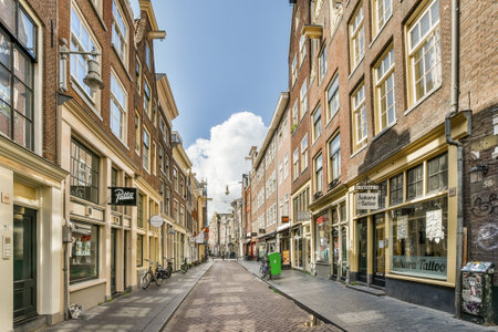 a city street with buildings and people walking on the sidewalk in the middle of the street there is a blue sky aboveのeditorial素材