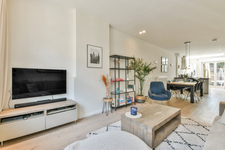 a living room with a tv on the wall and some plants in the vases next to the coffee tableのeditorial素材