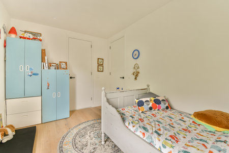a childs room with a bed, cupboards, and other things on the wall is painted whiteのeditorial素材