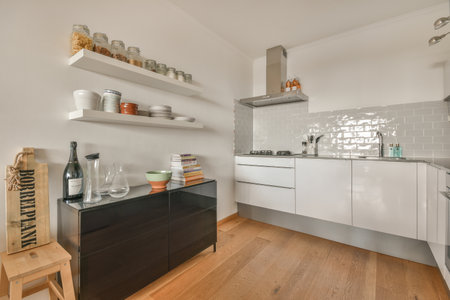 a kitchen with white walls and wood flooring in the center of the room, there is an open shelf on the wallのeditorial素材