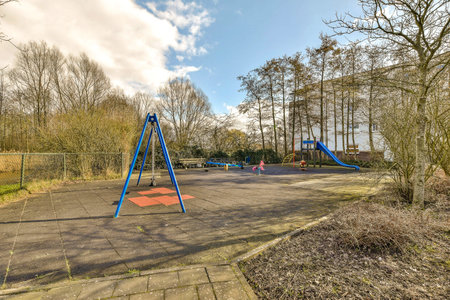 an empty playground with swings and climbing equipment in the fore - image is taken from below, but...