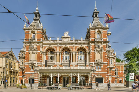 Amsterdam, Netherlands - 10 April, 2021: an old building in the middle of town, with people walking...