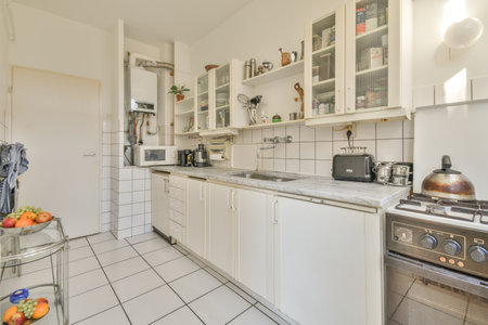 a kitchen with all white cabinets and appliances on the counters, including an oven, dishwasher, toaster, microwaveのeditorial素材