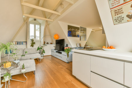 Amsterdam, Netherlands - 10 April, 2021: a kitchen and living room in an attic style home with white walls, wood flooring and exposed ceilingsのeditorial素材