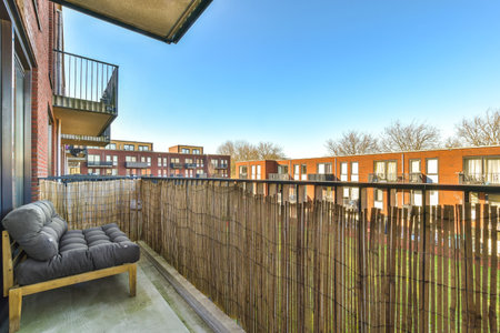 a balcony with a chair and some buildings in the background, taken from an apartment window looking out onto the streetの写真素材