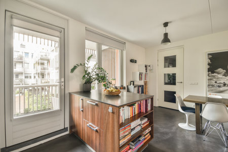 a living room with an open door and books on the shelves in front of the bookcase, next to a dining tableのeditorial素材