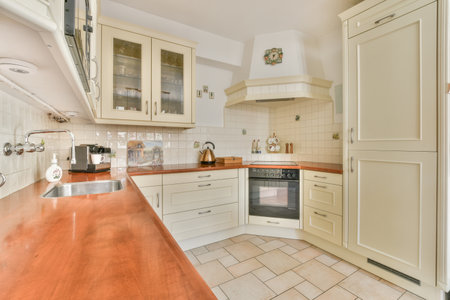 a kitchen with all white cabinets and wood counter tops in the center of the image is an open door leading to the left sideのeditorial素材