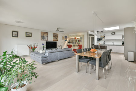 a living room with white walls and wood flooring in the center of the room is an open kitchen areaのeditorial素材