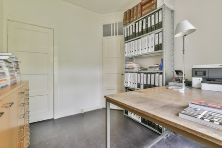 a home office with many files on the desk and bookshels in front of the door to the roomのeditorial素材