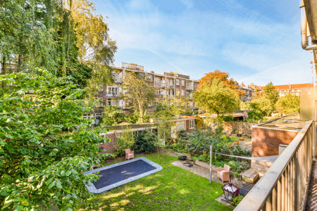 a backyard with trees, bushes and lawns in the fore - image is taken from an apartment balcony windowのeditorial素材