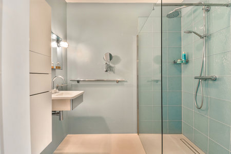 a modern bathroom with blue tiles and glass shower door, sink and toilet in the background is white...