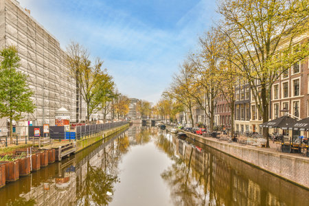 a canal in the middle of an urban area with buildings on both sides and trees lining the side of the riverのeditorial素材