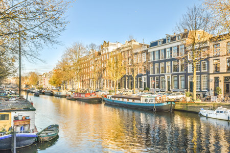 a canal with boats in the water and buildings on both sides, as seen from across the river there is a clear blue skyのeditorial素材