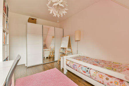a girls room with pink walls and white furniture, including a bed, desk, mirror and wardrobesのeditorial素材