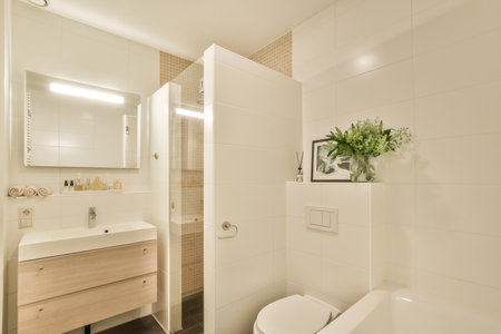 Amsterdam, Netherlands - 10 April, 2021: a bathroom with a toilet, sink and plant in the corner next to the bathtub thats on the wallのeditorial素材