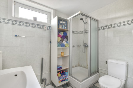 a bathroom with a toilet, sink and shower stall in the same color as it appears on the tile floorのeditorial素材