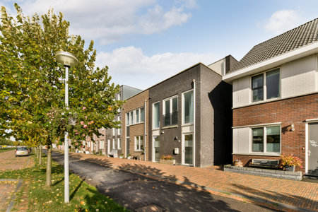 a street with houses and trees in the middle part of the photo is taken on a sunny, clear dayのeditorial素材