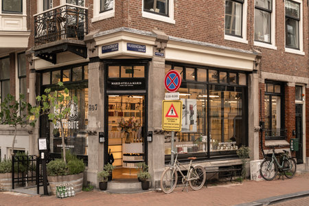 Amsterdam, Netherlands - 10 April, 2021: a bike parked in front of a store on the side of a street...