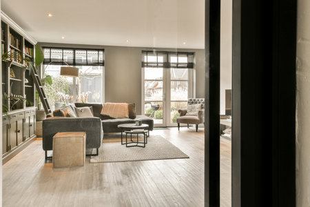 a living room with couches, chairs and books on the shelves in the room is very light wood flooring