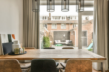 a table and chairs in front of a window with an open door leading to the back yard, where there is...