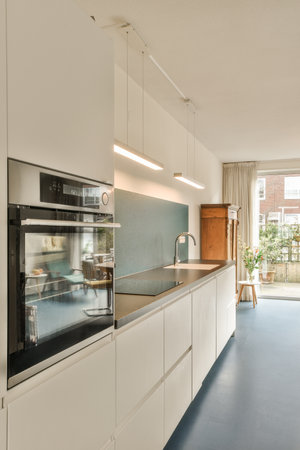 a modern kitchen with white cabinets and blue flooring in the center of the image is an open door...