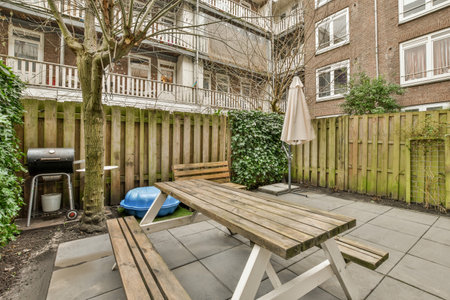 a backyard area with a picnic table and grill in the back yard, surrounded by plants and trees on...