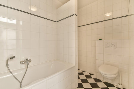 a white bathroom with black and white checkered tiles on the floor, along with a toilet in the...