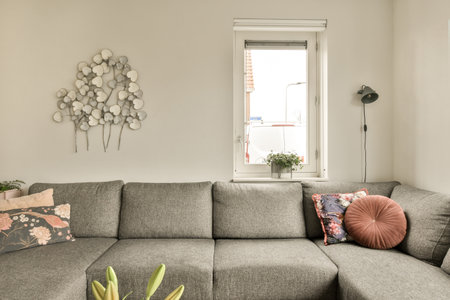 a living room with a couch and some decorative objects on the wall in front of the couch is made out of grey fabricの写真素材