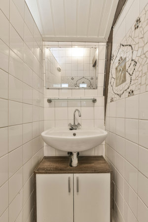 a bathroom with white tiles on the walls and wood flooring in front of the sink, there is a mirror above itの写真素材